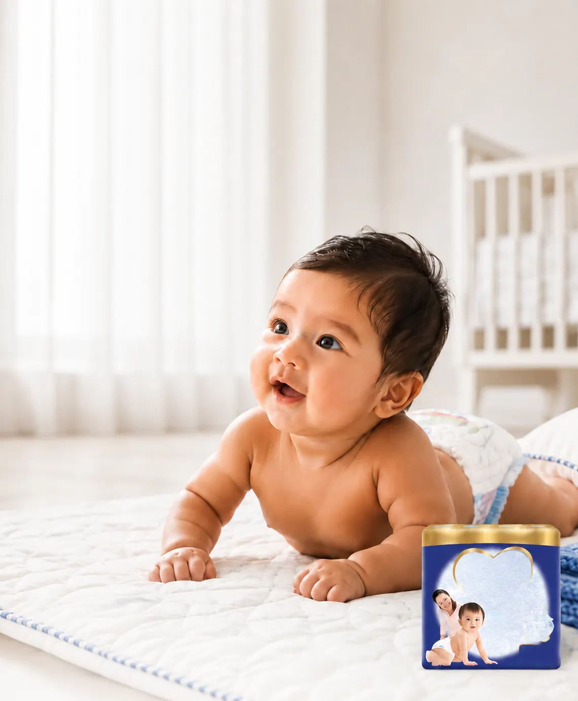 Baby crawling on a soft white bed beside MamyPoko Pants pack artwork